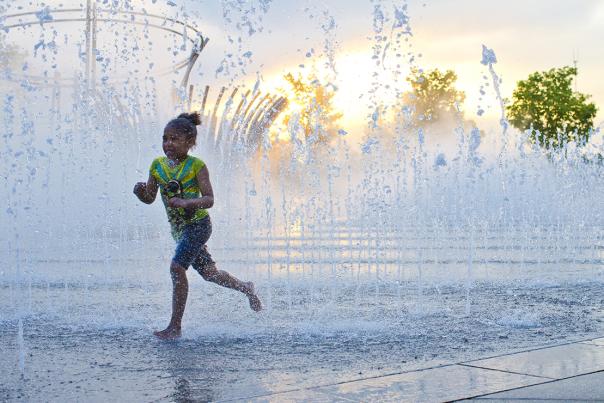 Girl running through fountains at Bicentennial Park