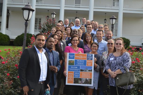 group of people holding a poster in front of a white building