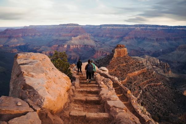 Visitors walk a trail atop a narrow ridge in Grand Canyon National Park.