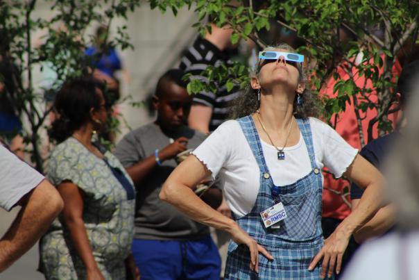 Woman looking up using eclipse viewing glasses at the Rochester Museum & Science Center during the 2017 Total Solar Eclipse