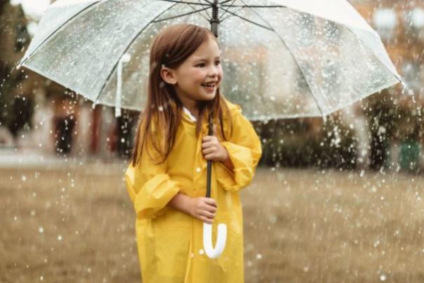 child in rain car holding an umbrella in the rain
