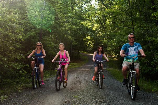 family biking on a path in the forest