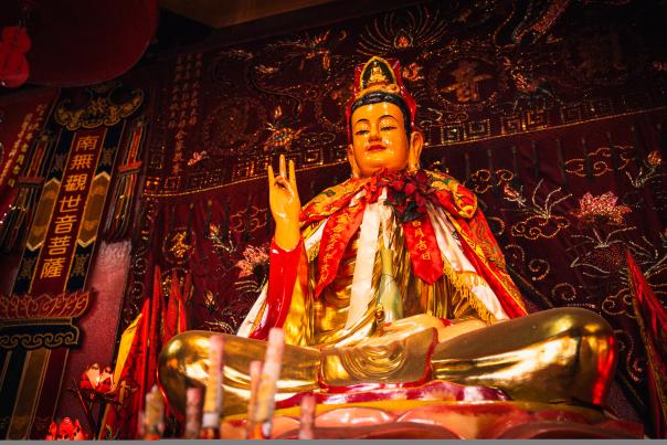 A statue of Buddha on a vibrantly decorated altar