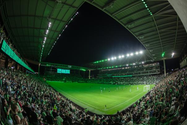 Photo with a fish-eye perspective showing off the field during an Austin FC match and the stands packed with fans.