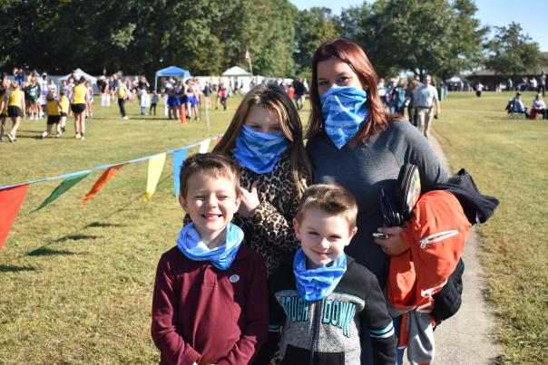 family with masks at a cross country track meet