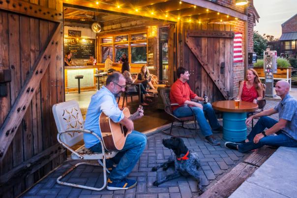 People Playing Guitar And Enjoying A Beer Outside Of A Brewery In Wilmington, NC