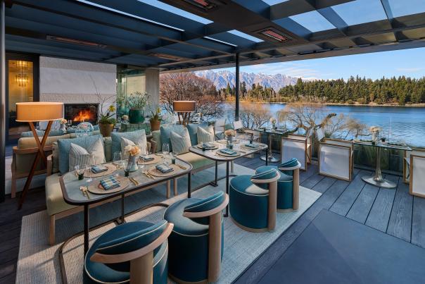 Image of high end luxury hotel patio looking with elegant tableware set up for al fresco dining, looking out over Lake Whakatipu and The Remakables.