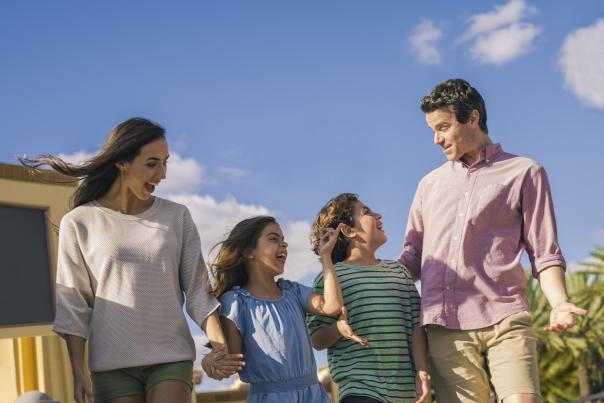 An hispanic family walking in a theme park.