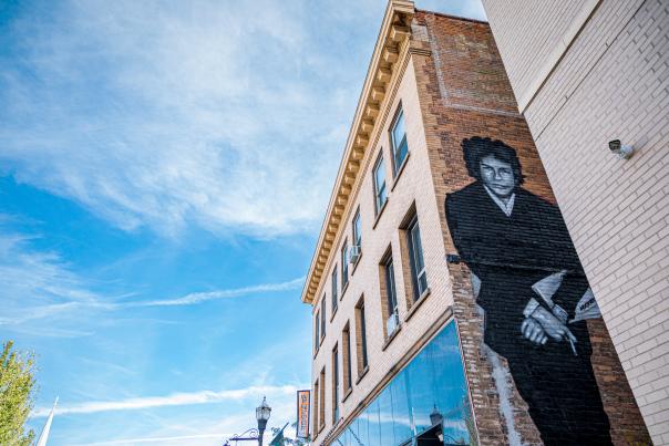 black mural of singer bob dylan on a brick building