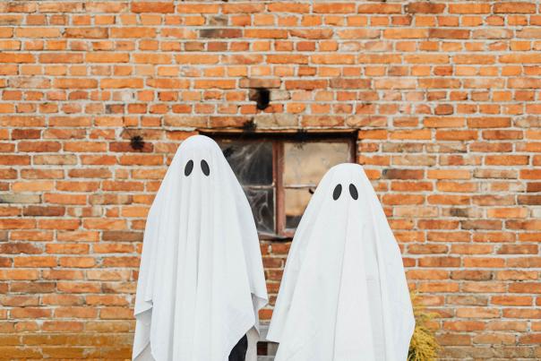 Two people dressed in sheet ghost Halloween costumes