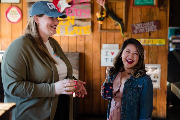 Two women drinking beer at a bar