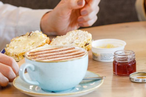 Three coffees and two cakes on a brown table