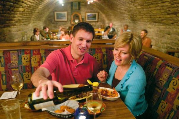 A man pours wine into a glass for his date at Doe's Eat Place located in Fort Smith, Arkansas.