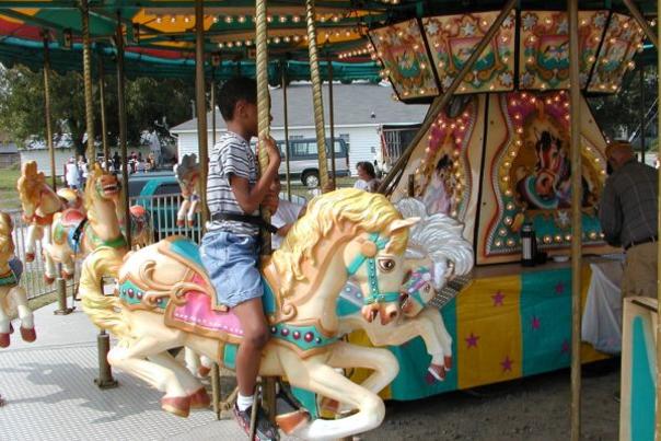A child riding on a merry-go-round at the Clayton Harvest Festival in Clayton, NC.