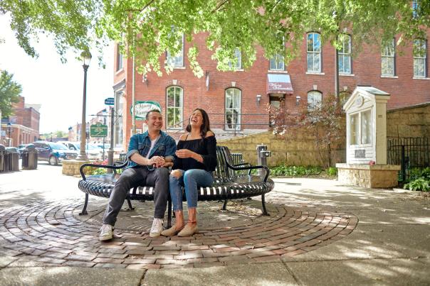 Couple sitting in a park under a tree on Main Street in Galena.