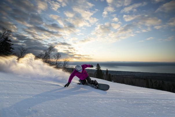 Snowboarder with Lake Superior in background at Lutsen Mountains