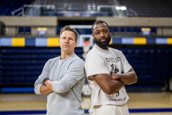 Wade & Diener on basketball court, back to back with arms crossed