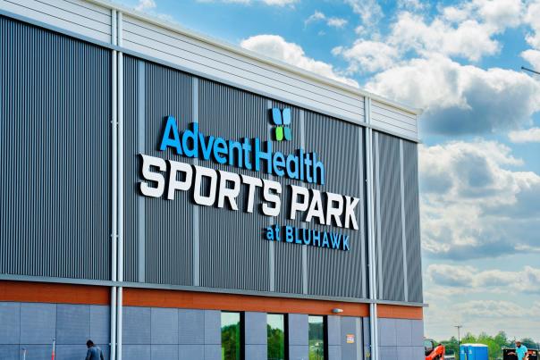 Signage on the front of the AdventHealth Sports Park at Bluhawk building
