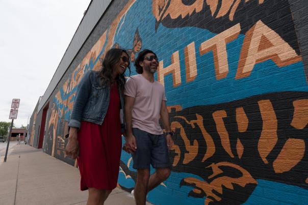Couple walking by Mural