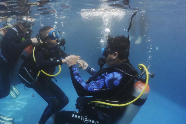 fotografía de menor practicando buceo en una piscina