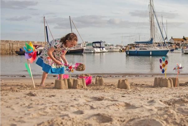 Kids building sand castles on Lyme Regis Beach