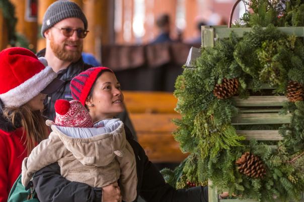 A family looking at a for sale wreath dressed for the winter shopping in downtown Golden