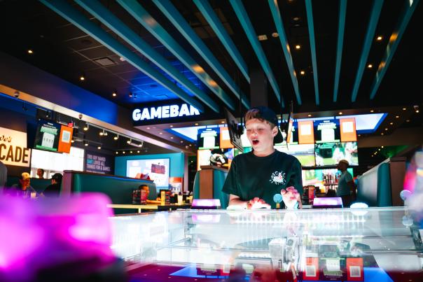 young boy playing a game at Dave and Busters