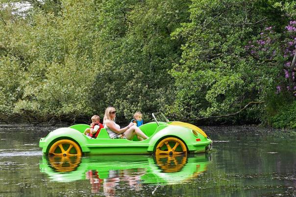 A family in a green pedalo car on Singleton Boating lake.