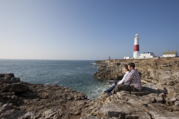 Man and woman sitting on the rocks at Portland Bill, Dorset