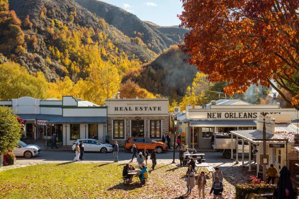 Street view of an old historic town with autumnal trees and mountains in the background