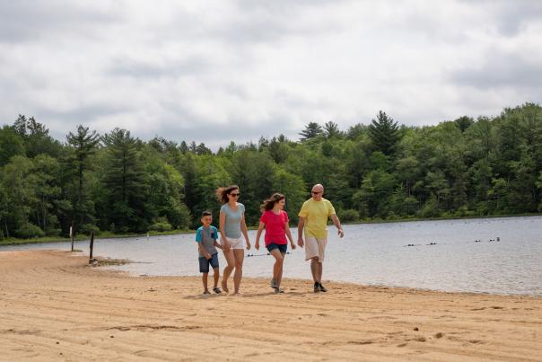 A family enjoys a walk on the beach at Hickory Run State Park