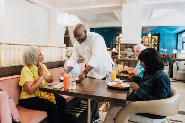 Chef Andrew Black serving food to patrons at Perle Mesta