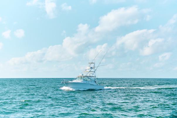 Large white charter boat in turquoise water and bright blue sky