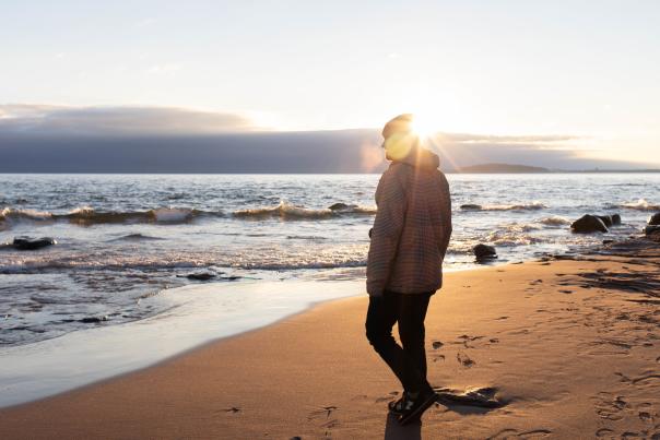 A man walking on the beach at sunrise in the Upper Peninsula of Michigan