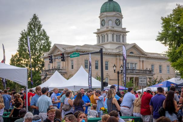 Tents with vendors and a crowd are shown at Twilight Criterium 2021.