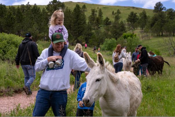 Family with children petting a burro outside