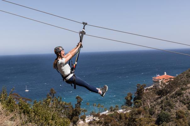 Woman on zip line tour on Catalina Island with ocean views
