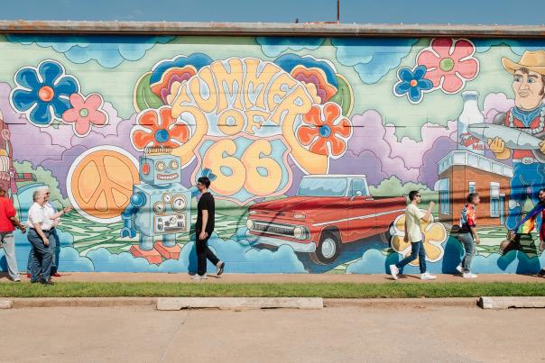 People walking past the "Summer of 66" mural in OKC's 39'th Street District.