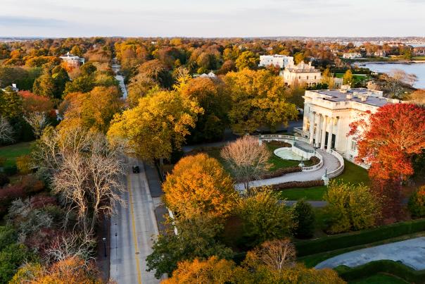 Marble House Newport Mansion on Bellevue Ave in the fall with bright foliage and a glimpse of the water to the right