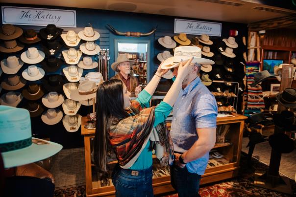 A couple trying on hats at Persimmon Hill gift Shop
