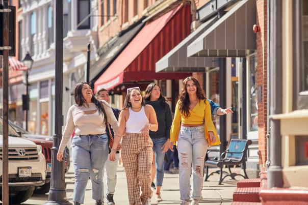 Three friends walking down Main Street in Galena, laughing, and looking at a storefront.