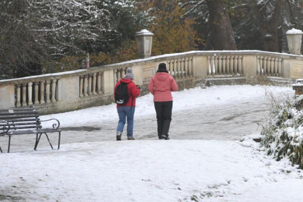 A snow covered bridge with two people walking across it