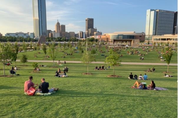 People sitting on the Great Lawn at Scissortail Park