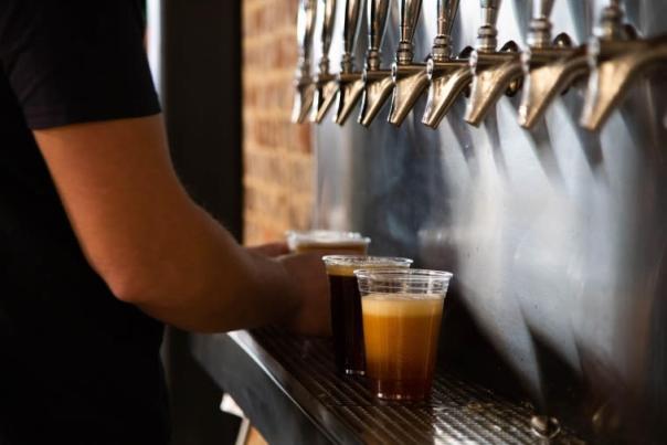 three colors of beer in clear cups