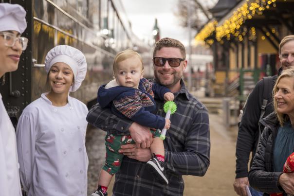 Dad holding kid at train museum Christmas event
