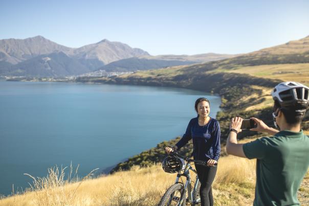 Couple Biking along Jacks Point. Stopping for a scenic photo.