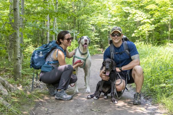A couple with their dogs hiking near Tahquamenon Falls, located in the Upper Peninsula of Michigan