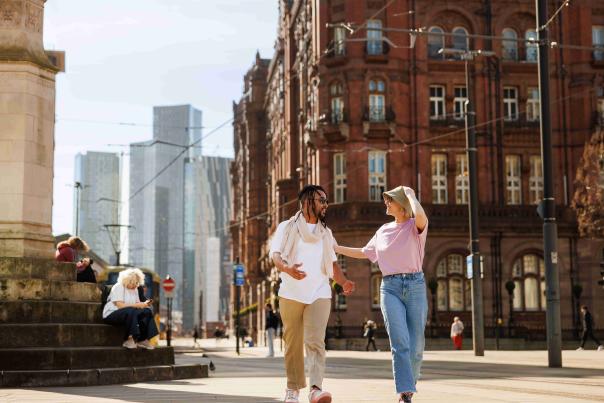 Couple walking through st peter's square in manchester