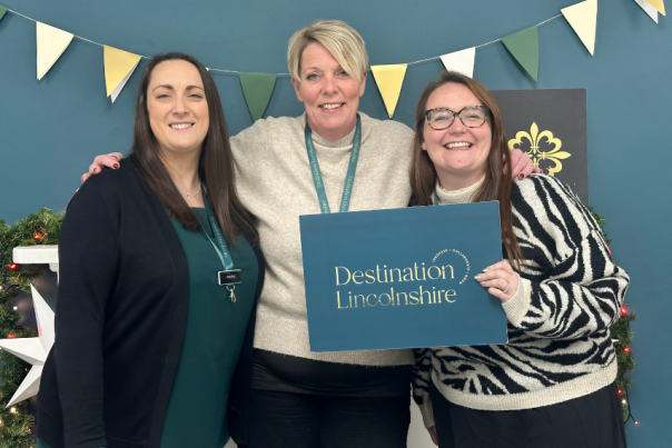 three people holding a Destination Lincolnshire sign