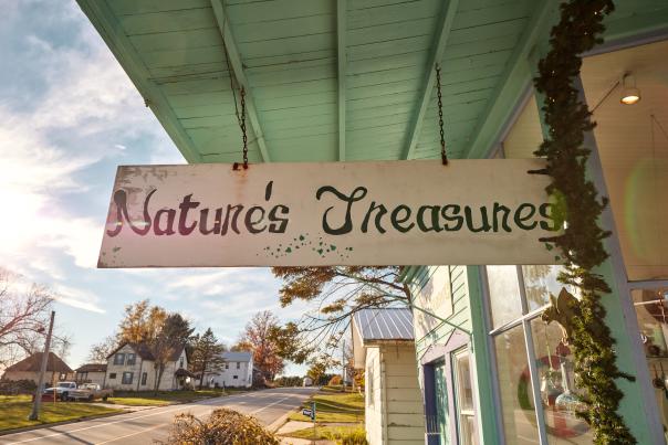 Side-view of Nature's Treasures storefront, in the afternoon. The building is colorful with the sun setting in the background.